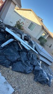 Construction debris pile with black trash bags and broken drywall during a junk removal job in Las Vega