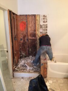 Call 4 Handyman technician performing bathroom demolition with wall studs exposed and debris removed