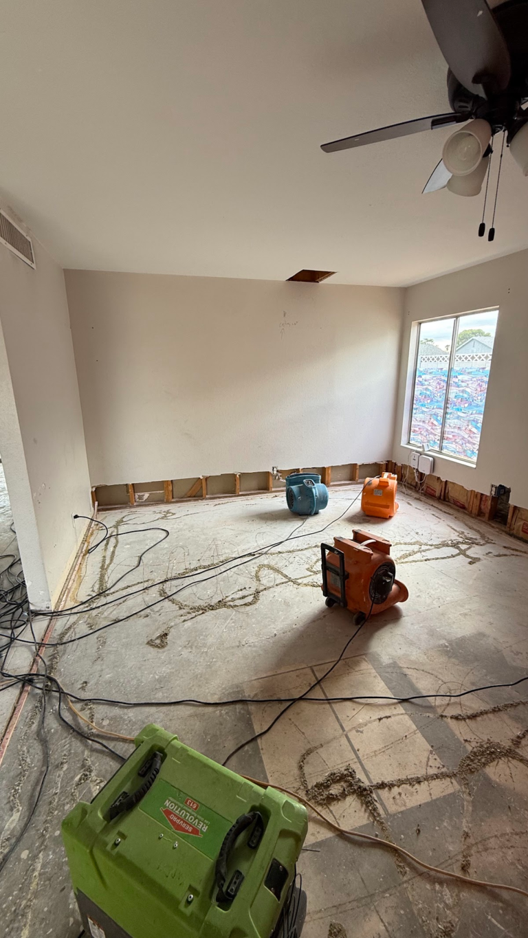 Air movers and dehumidifier in stripped room during the Las Vegas home restoration project.