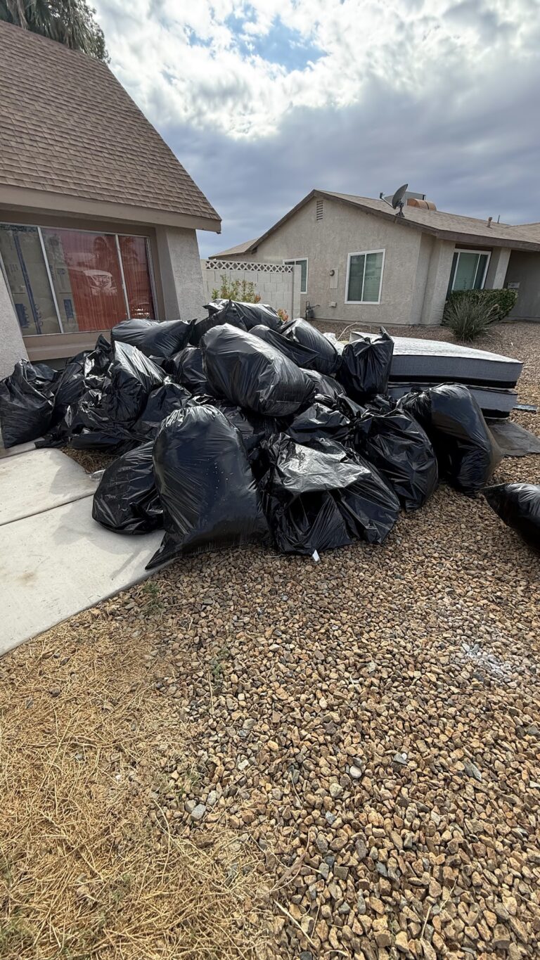 Bagged roofing debris beside front entry during the Las Vegas home restoration project.