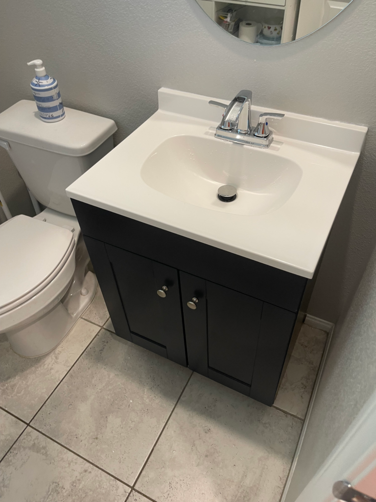 New black bathroom vanity with white sink countertop and chrome faucet installed in Las Vegas