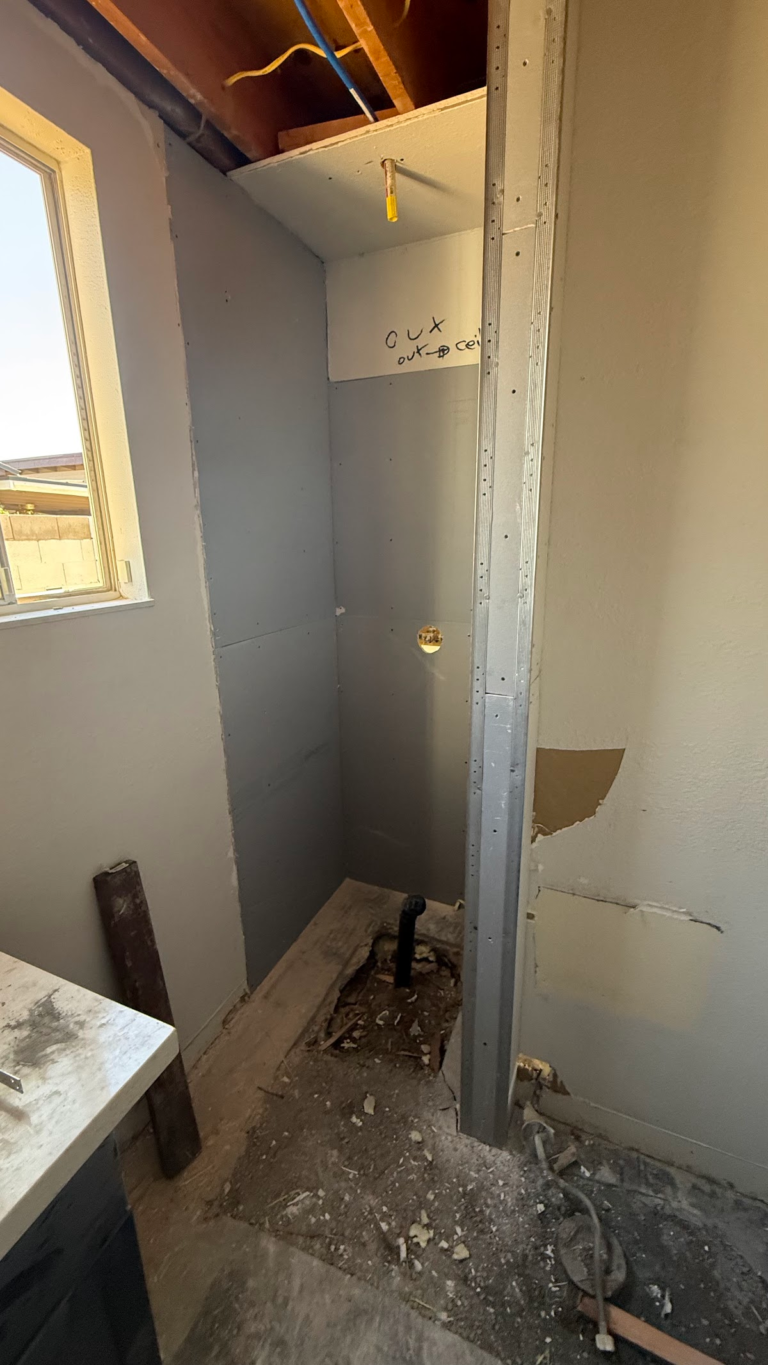 Bathroom shower demolition with exposed ceiling during the Las Vegas home restoration project.