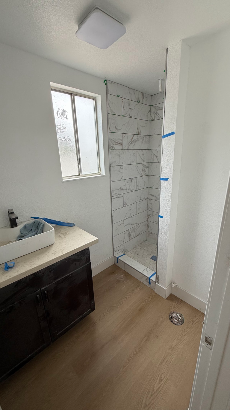 Bathroom vanity and tiled shower installation during the Las Vegas home restoration project.