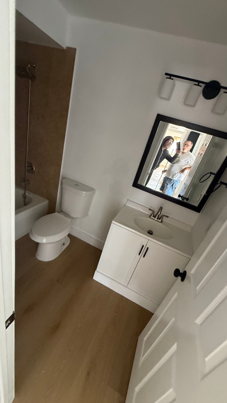 Bathroom vanity mirror and toilet during the Las Vegas home restoration project.