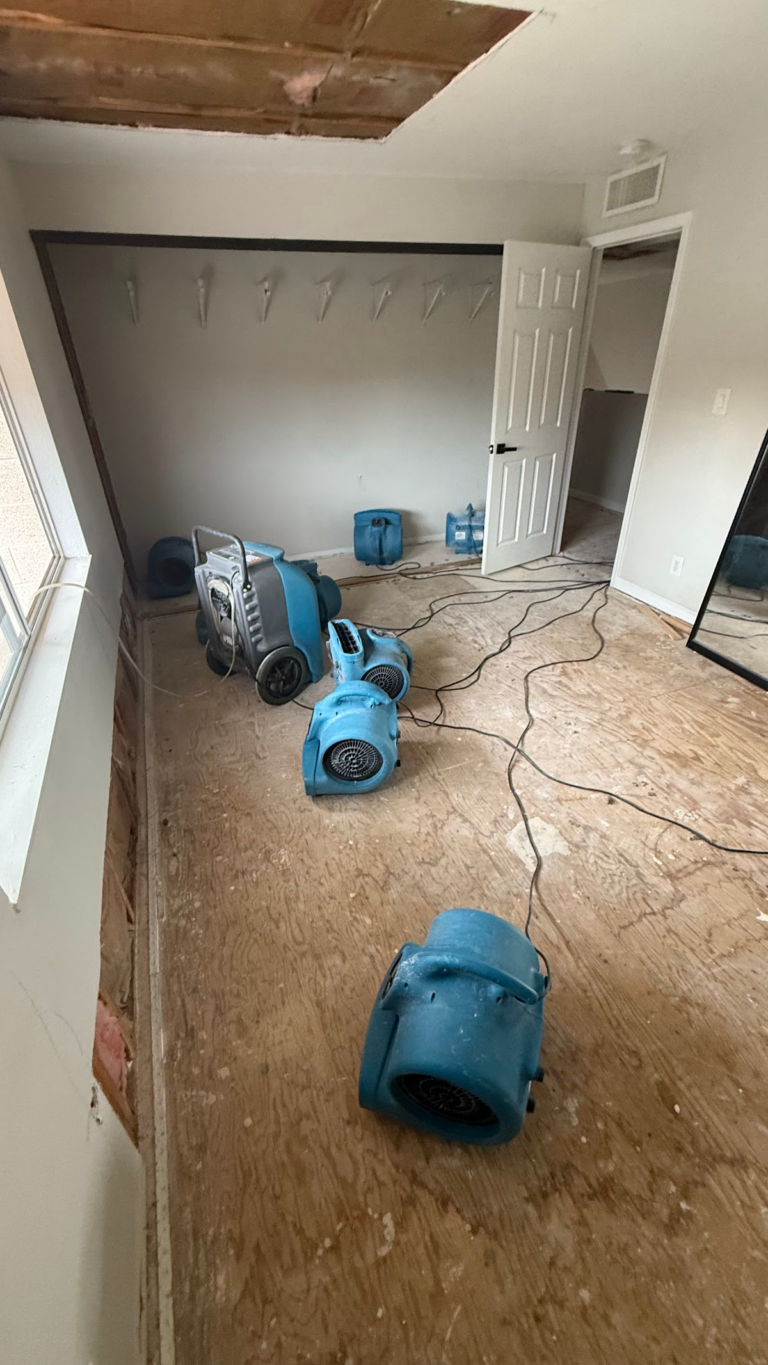 Bedroom air movers beneath ceiling opening during the Las Vegas home restoration project.