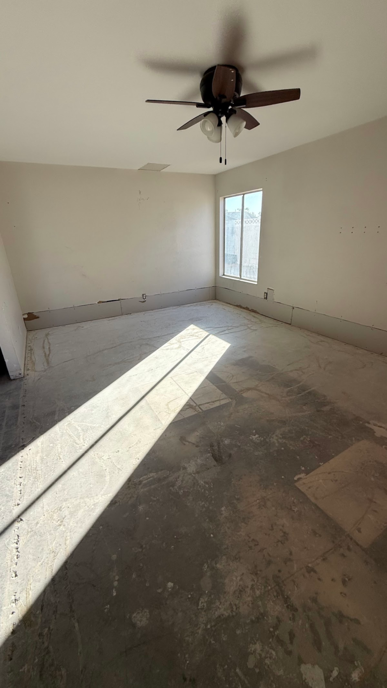 Bedroom floor preparation beneath window during the Las Vegas home restoration project.