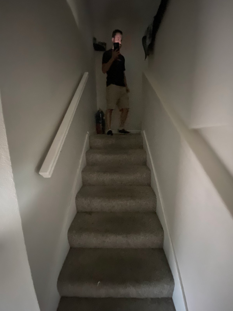 Carpeted staircase before restoration during the Las Vegas home restoration project.