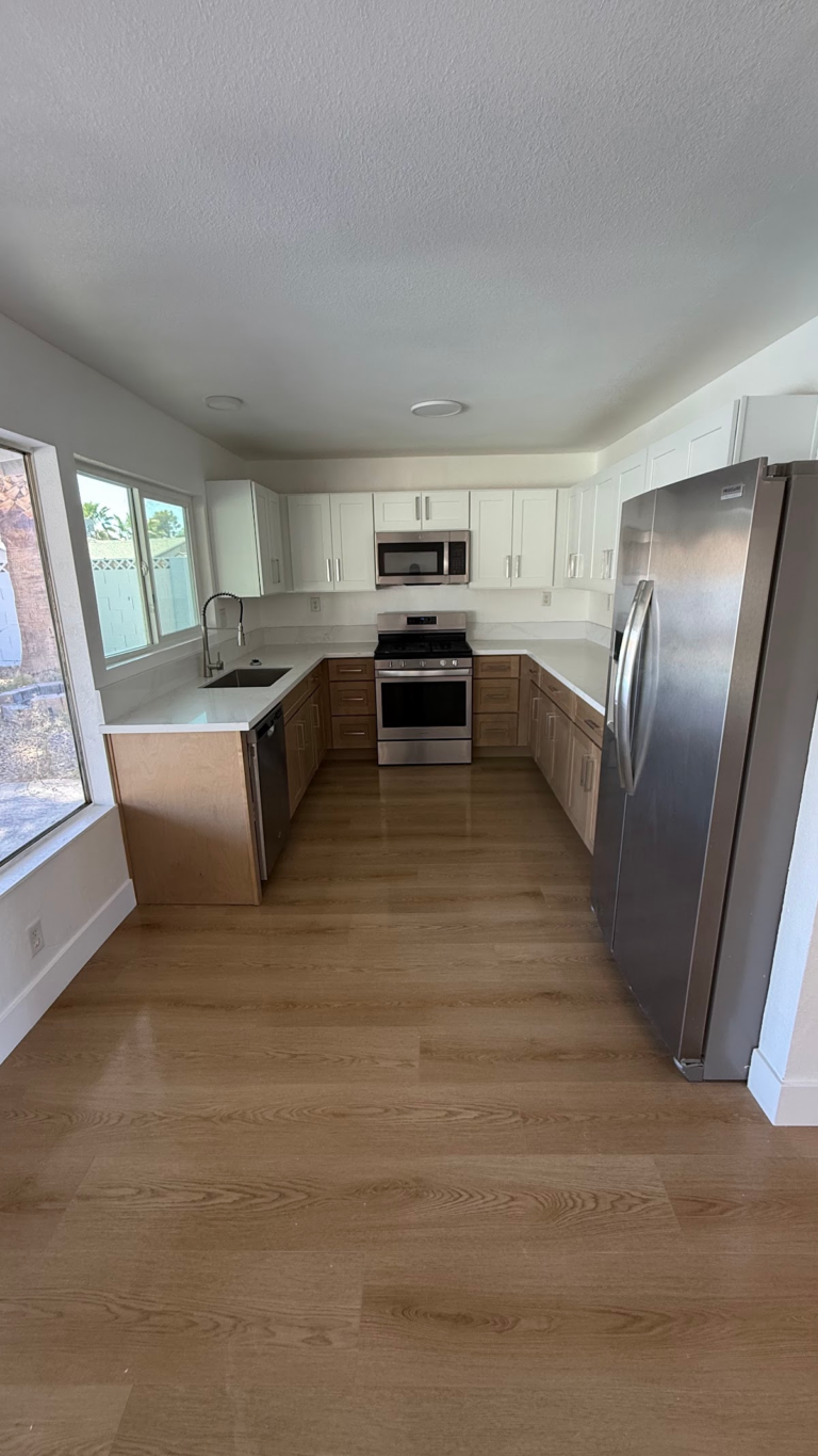 Completed kitchen with white cabinets and appliances during the Las Vegas home restoration project.