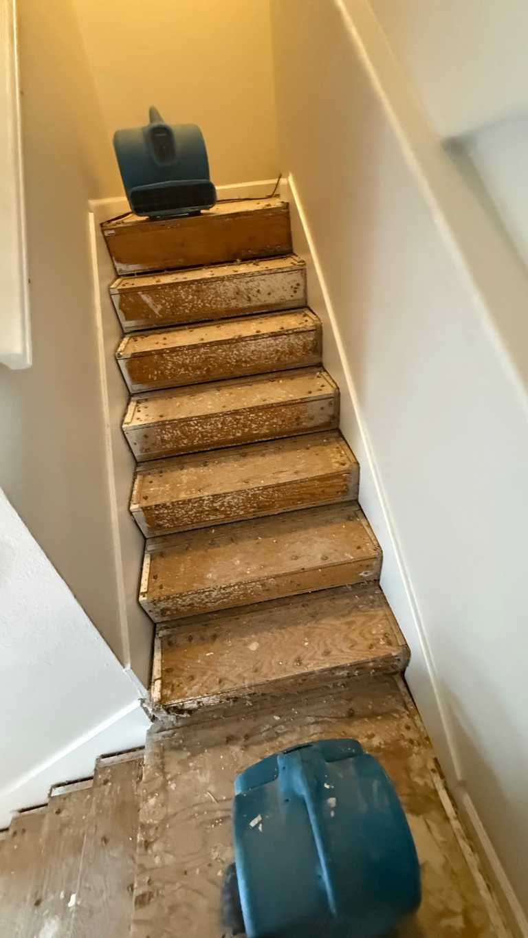 Drying fan at top of stripped staircase during the Las Vegas home restoration project.