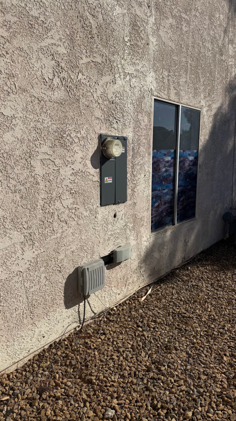 Exterior stucco wall with electrical service panel during the Las Vegas home restoration project.