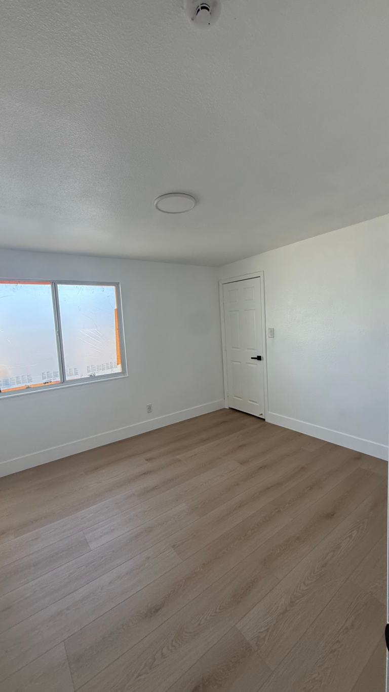 Finished bedroom floor and white walls during the Las Vegas home restoration project.