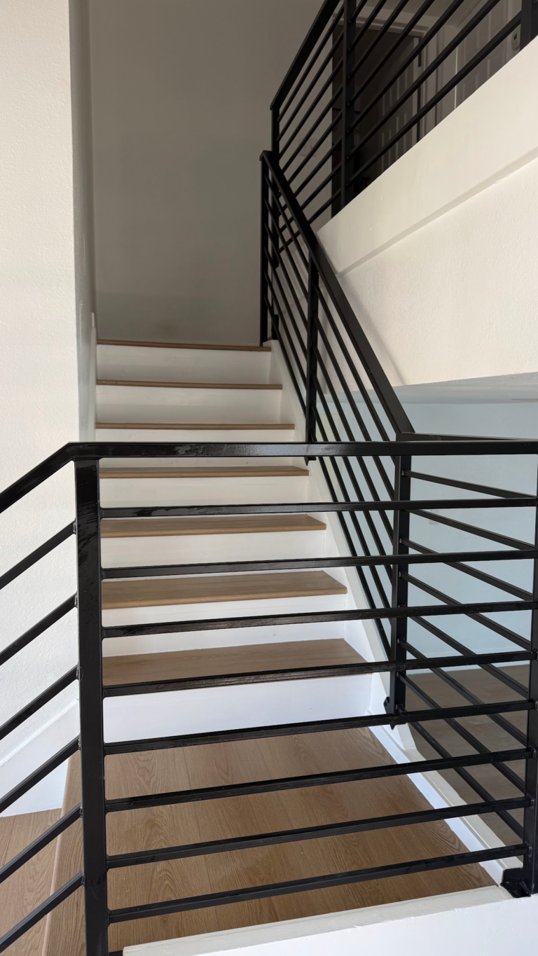 Finished staircase with horizontal black railing during the Las Vegas home restoration project.