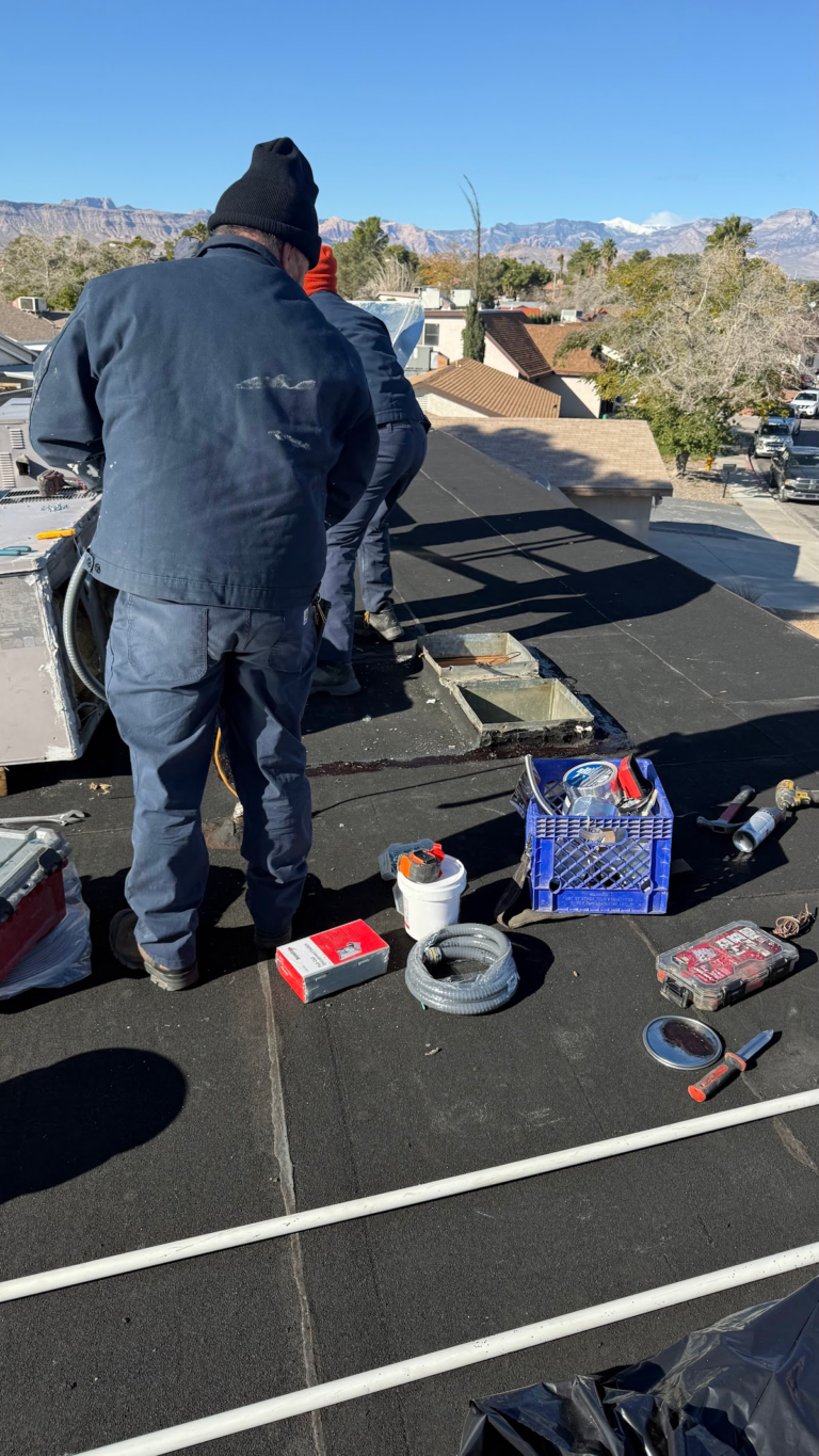Flat roof membrane installation around rooftop equipment during the Las Vegas home restoration project.