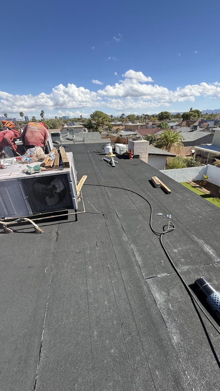 Flat roof membrane installation with rooftop HVAC during the Las Vegas home restoration project.