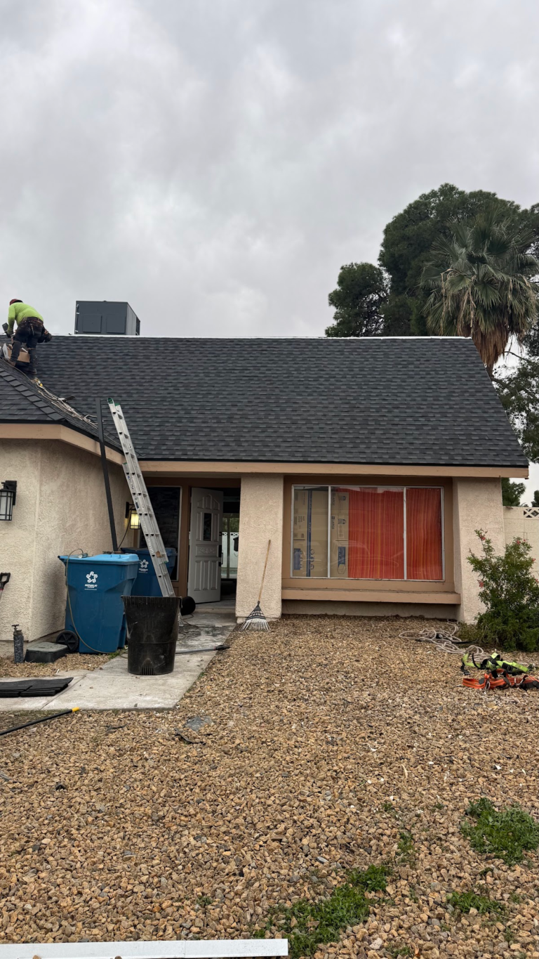 Front elevation with dark shingle roof during the Las Vegas home restoration project.