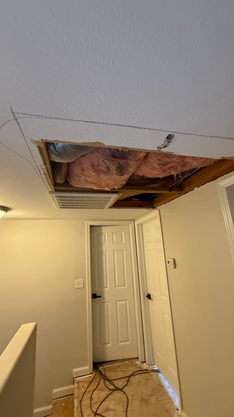 Hallway ceiling opening and exposed subfloor during the Las Vegas home restoration project.