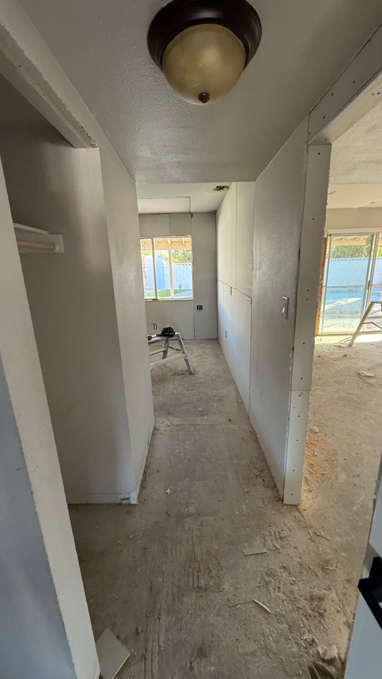 Hallway wall finishing before flooring during the Las Vegas home restoration project.