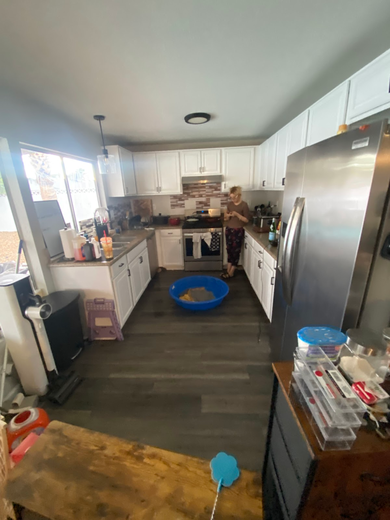 Kitchen with wood-look flooring and white cabinets during the Las Vegas home water-damage inspection.