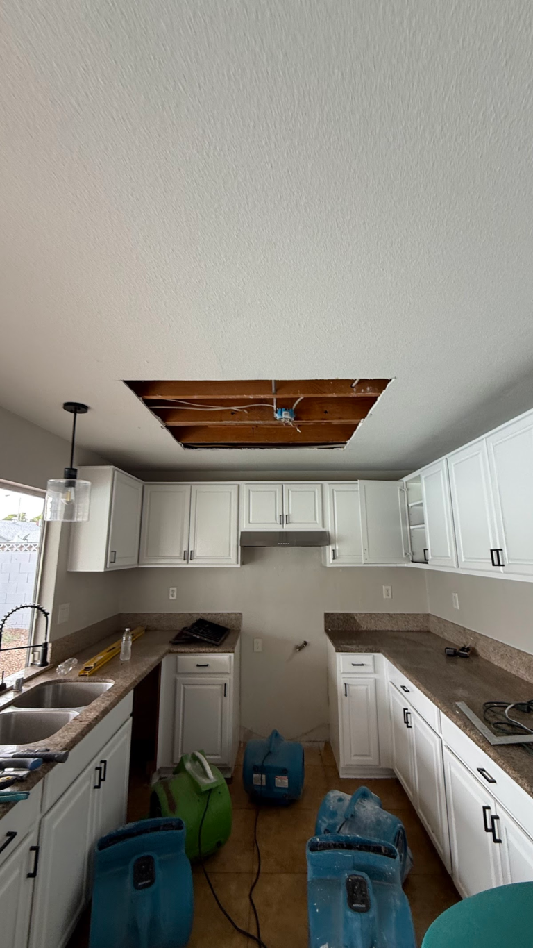 Kitchen air movers below ceiling opening during the Las Vegas home restoration project.