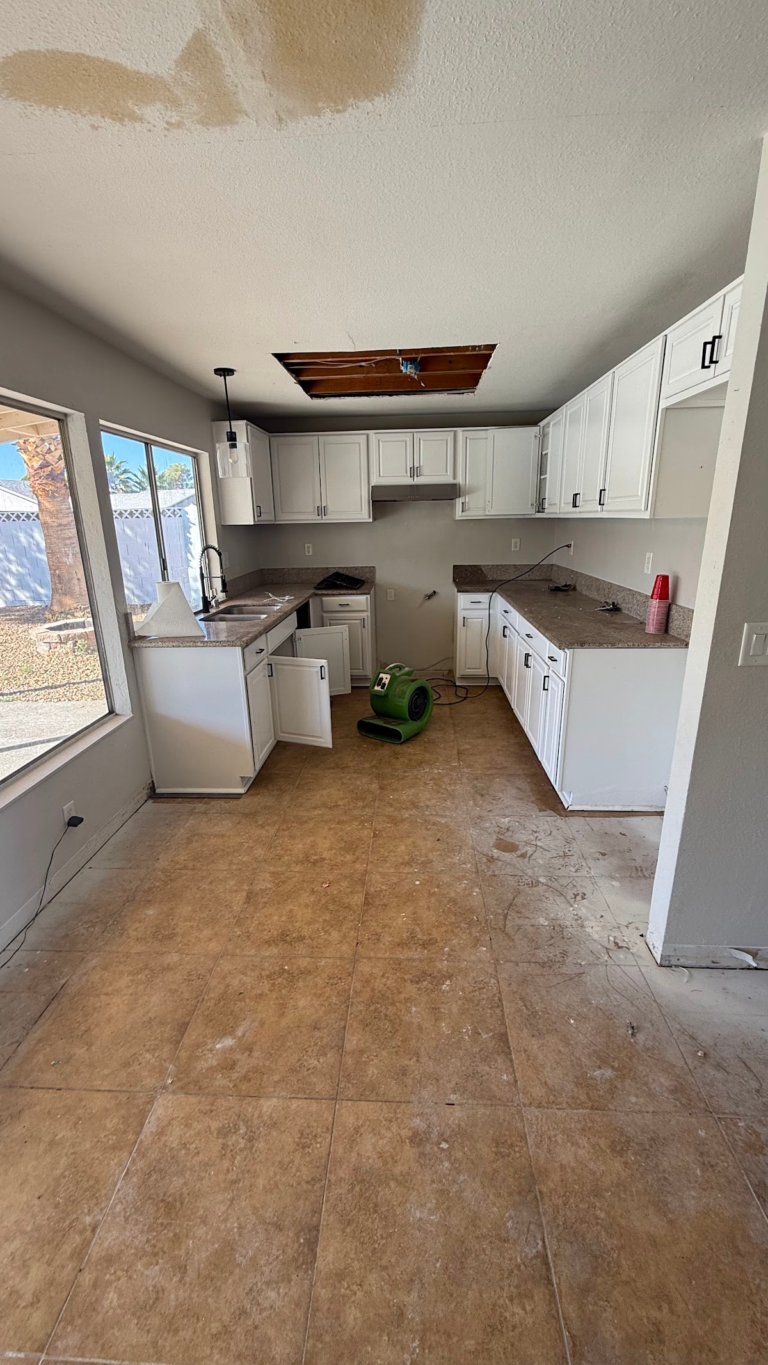 Kitchen floor removal and ceiling opening during the Las Vegas home restoration project.