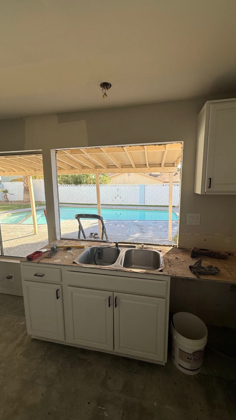 Kitchen sink and cabinets before rebuild during the Las Vegas home restoration project.