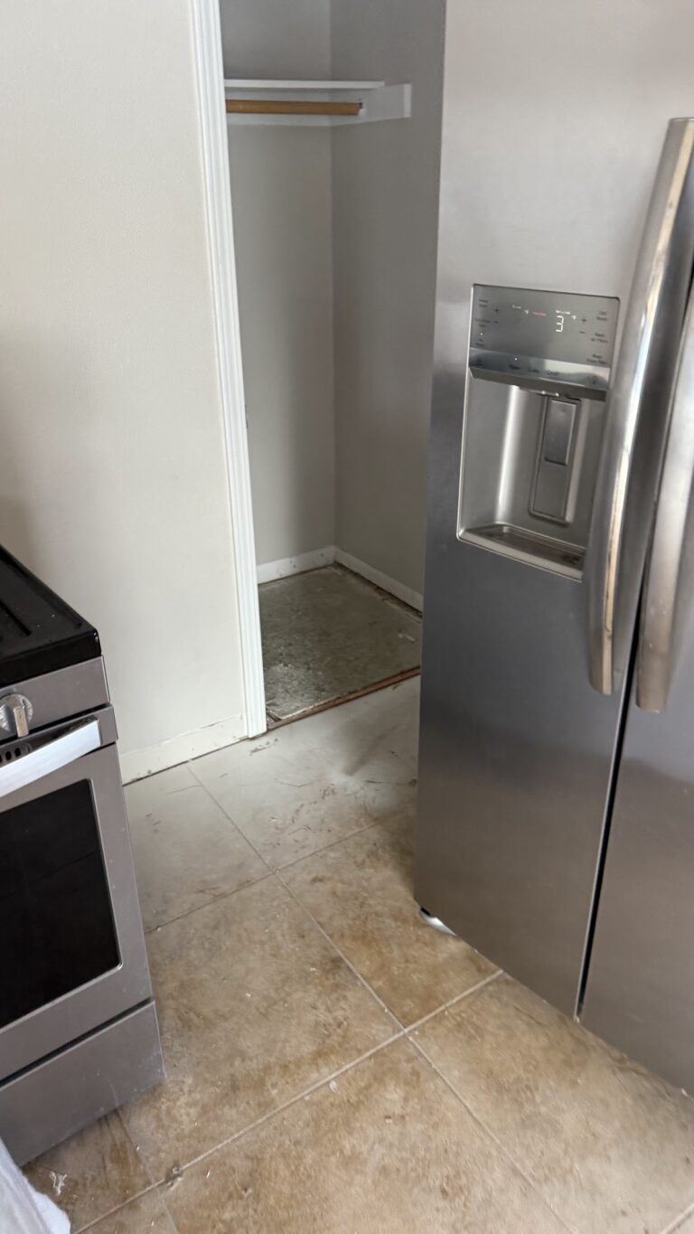 Kitchen tile floor beside refrigerator during the Las Vegas home restoration project.