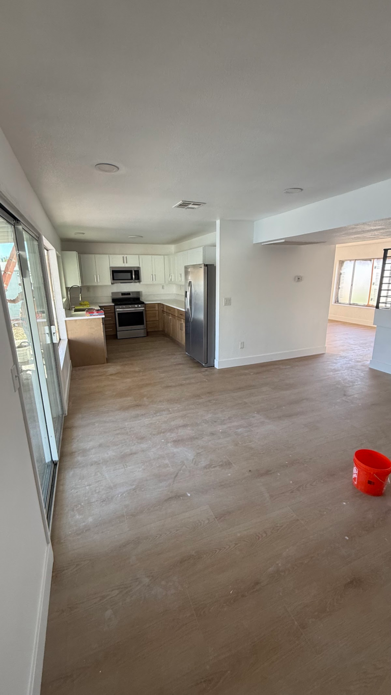 Open living area facing finished kitchen during the Las Vegas home restoration project.
