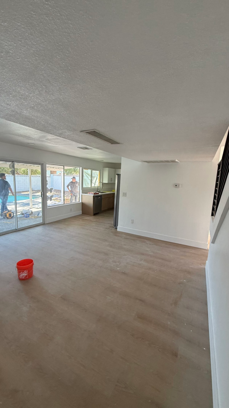 Open-plan living room with new flooring during the Las Vegas home restoration project.