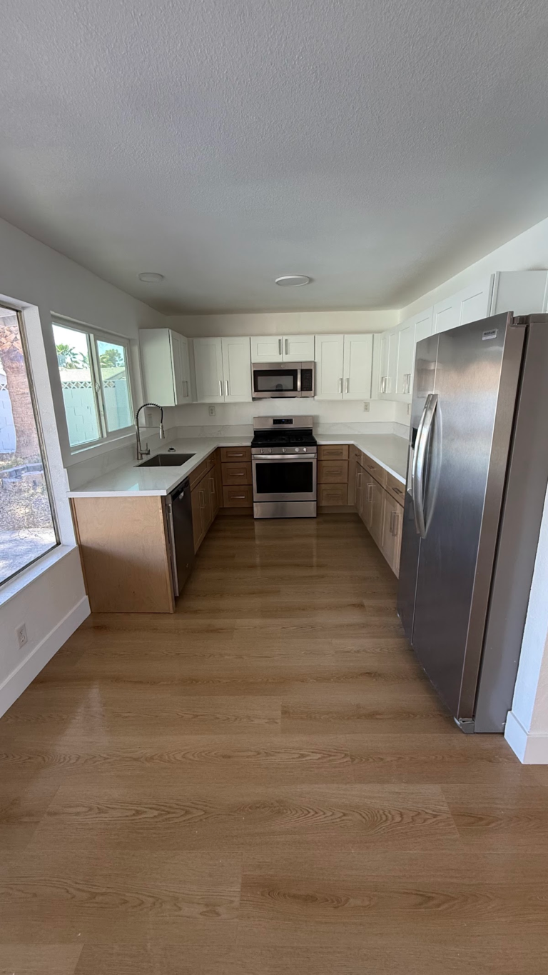 Remodeled kitchen with wood-look floor during the Las Vegas home restoration project.