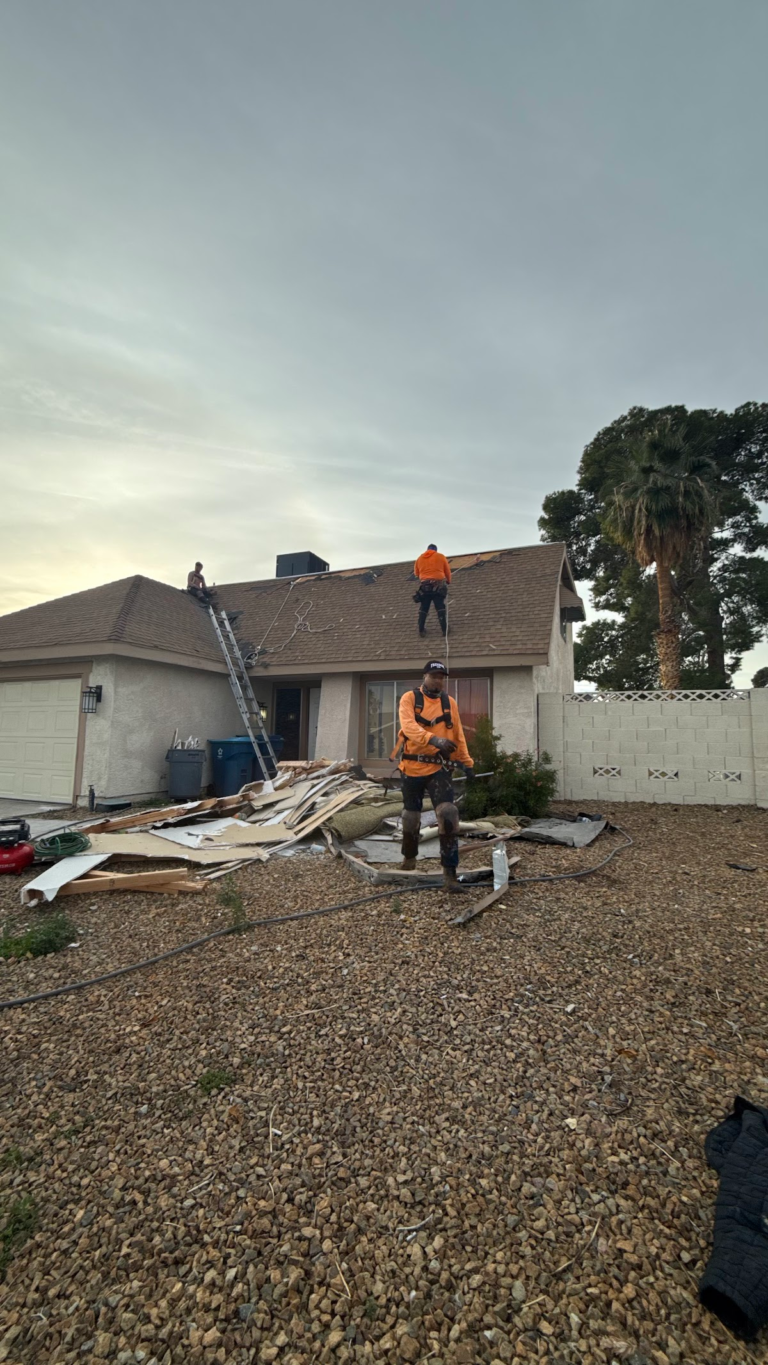 Roof replacement crew working above entry during the Las Vegas home restoration project.