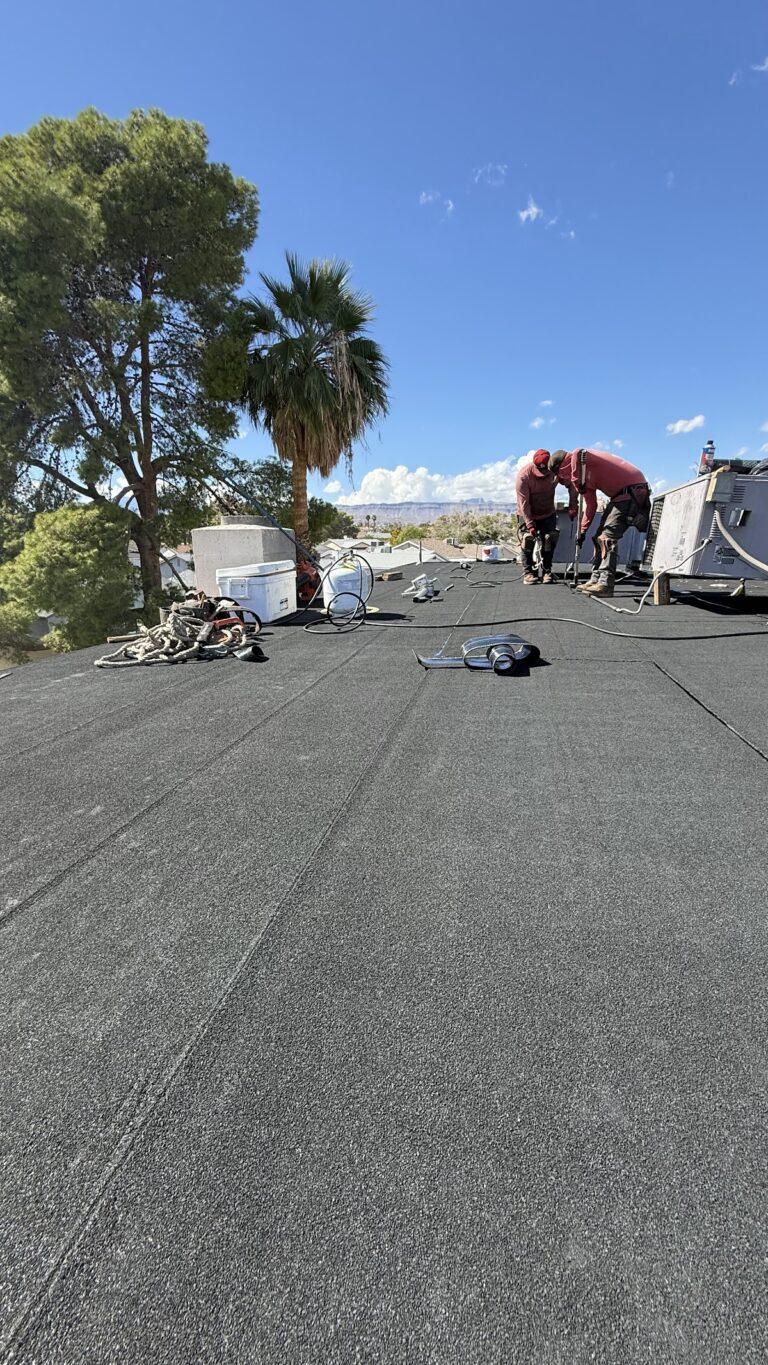 Roofing crew working beside HVAC unit during the Las Vegas home restoration project.