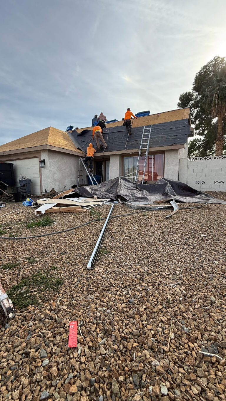 Roofing materials and crew at front elevation during the Las Vegas home restoration project.