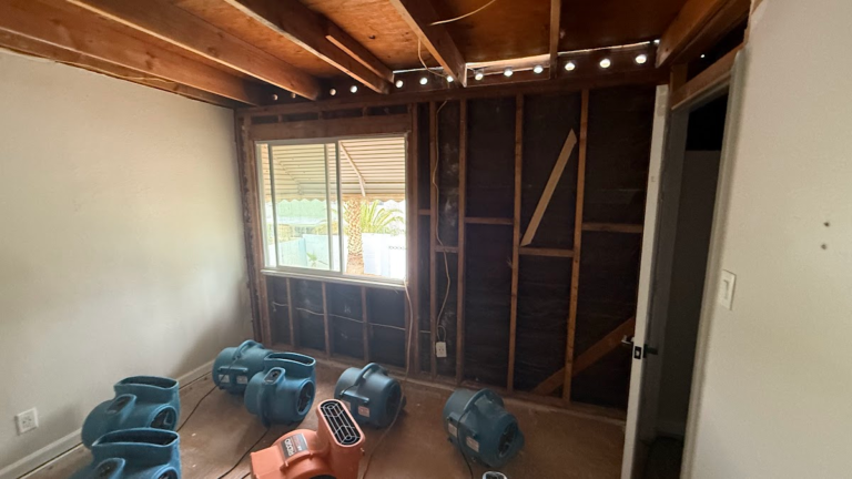 Room with exposed wall studs and ceiling joists during the Las Vegas home restoration project.