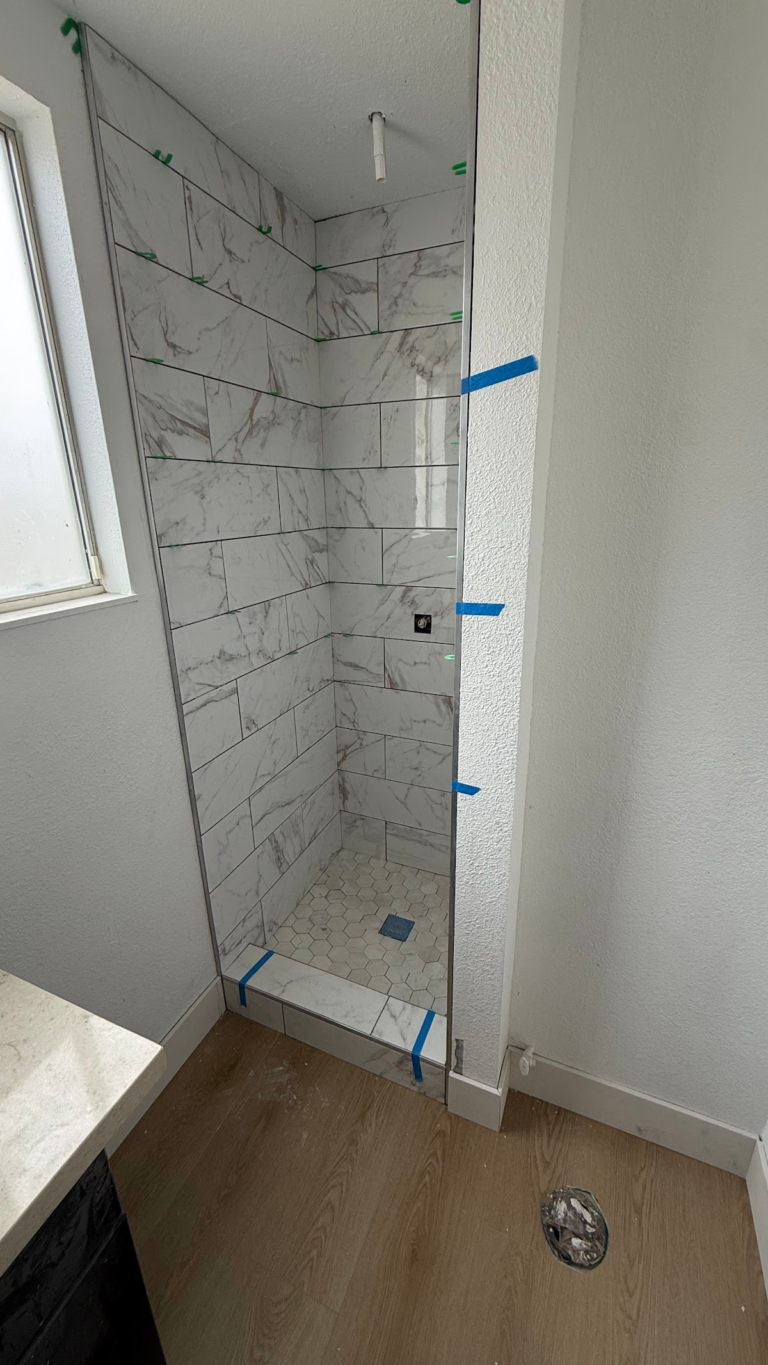 Shower glass installation with protective tape during the Las Vegas home restoration project.
