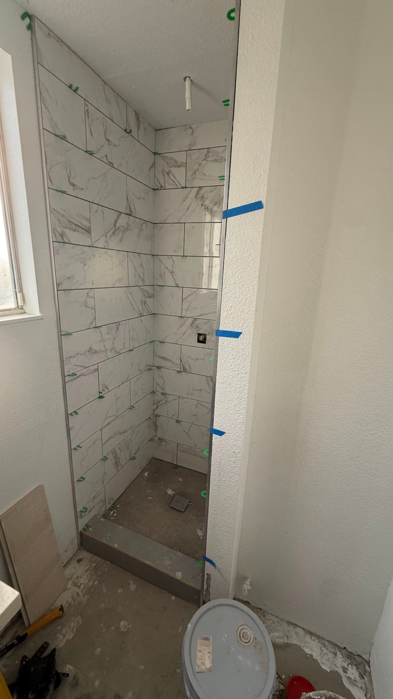 Shower tile and shower base installation during the Las Vegas home restoration project.