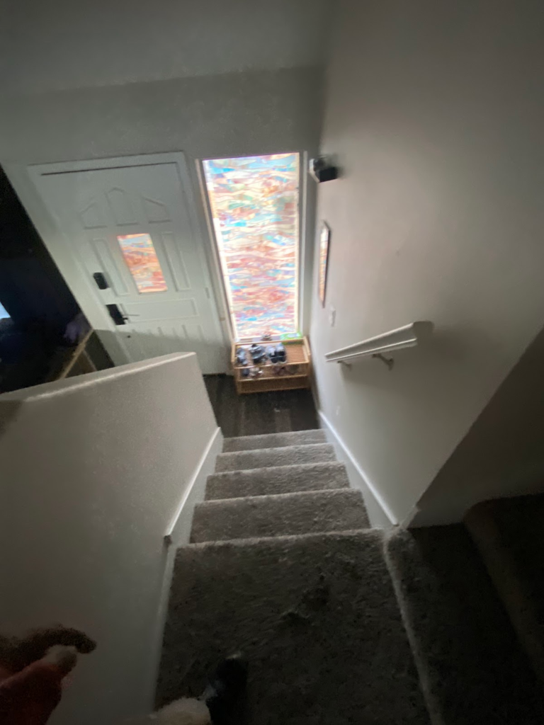 Stairway and front door before restoration during the Las Vegas home restoration project.