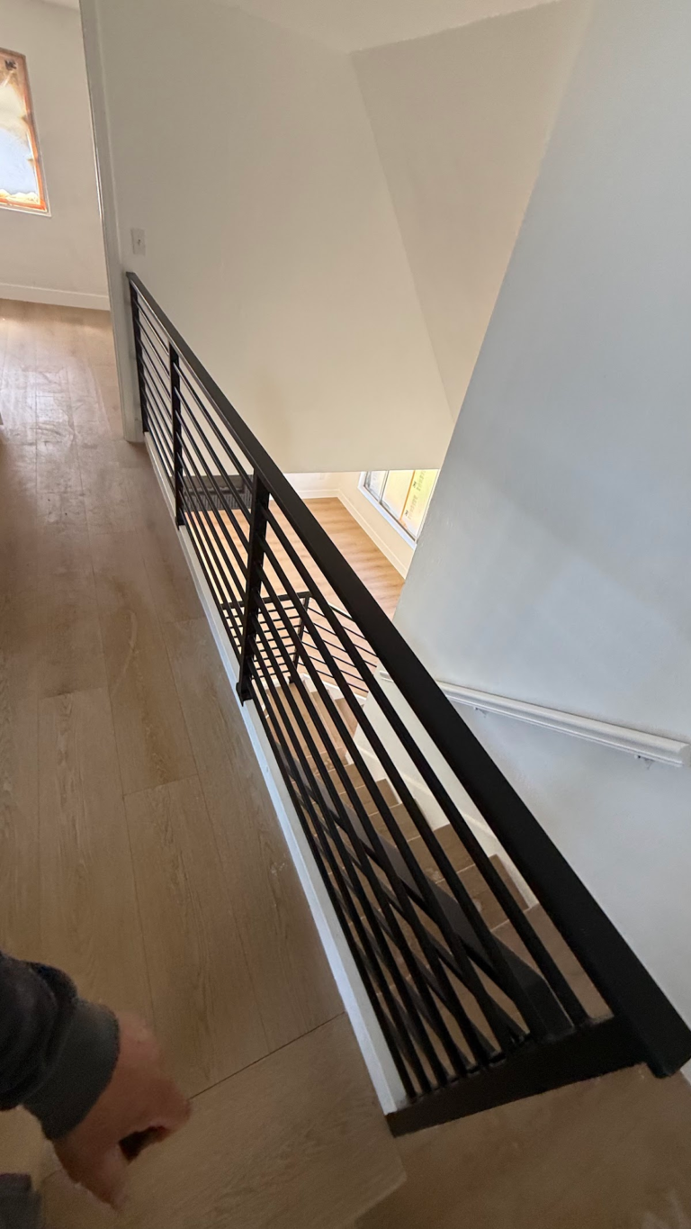 Upper landing flooring beside metal railing during the Las Vegas home restoration project.