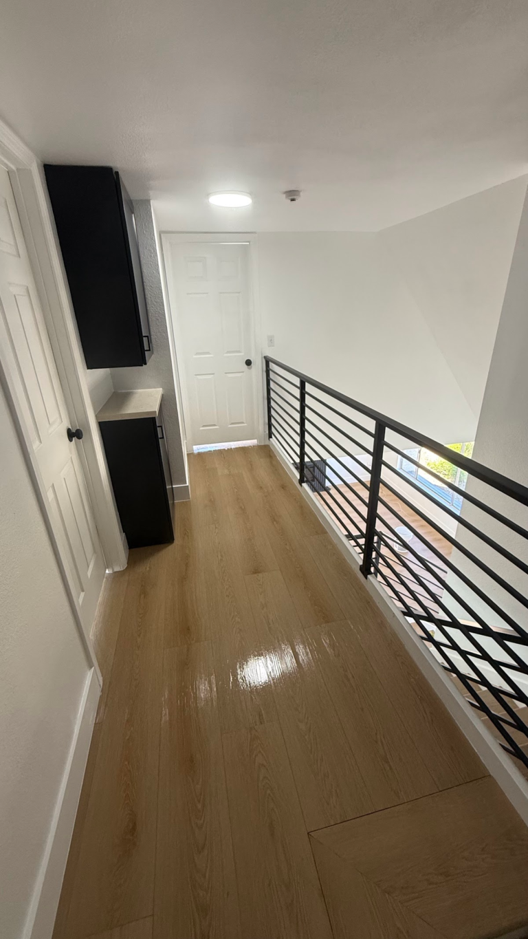 Upper landing with black railing during the Las Vegas home restoration project.