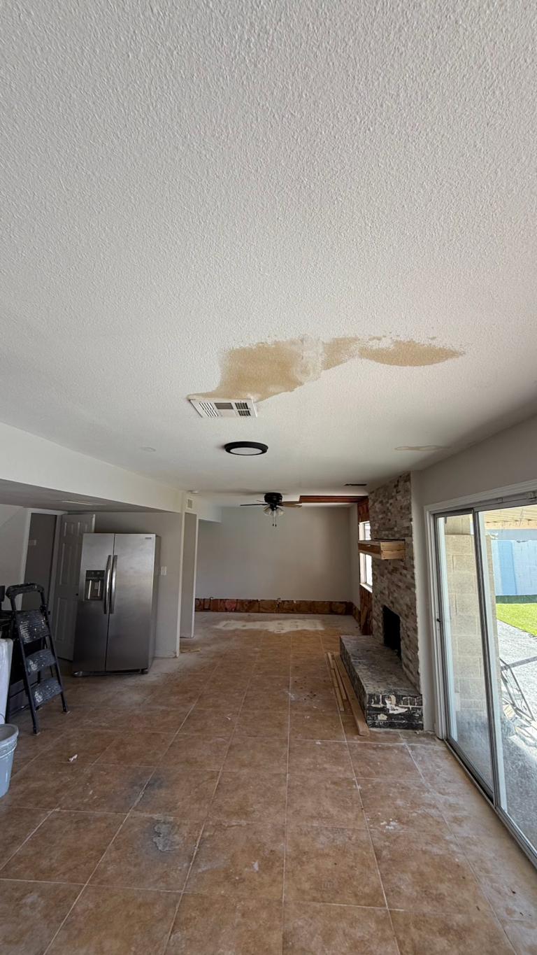 Water-stained ceiling above stripped kitchen floor during the Las Vegas home restoration project.