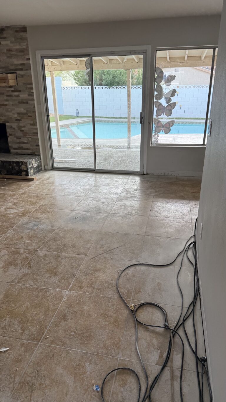 Wet tile floor beside sliding patio door during the Las Vegas home restoration project.